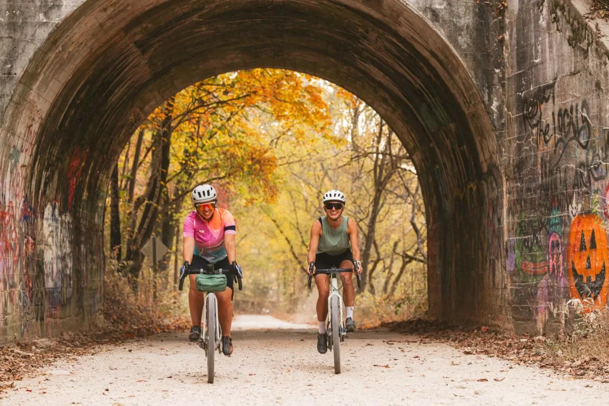 Cyclists riding through a tunnel on a Northwest Arkansas trail near Bentonville