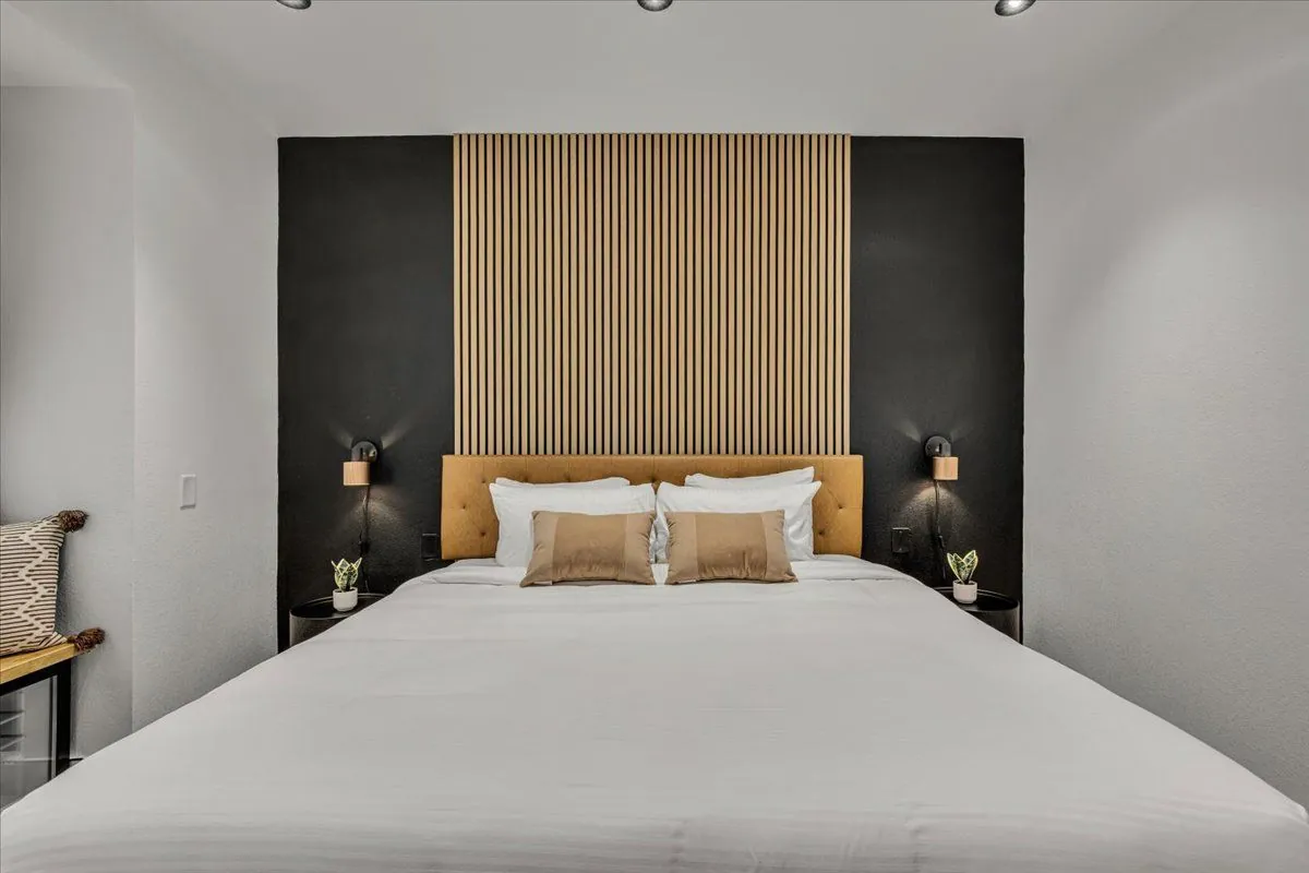 Boutique King – king bed against black and wood slat accent wall