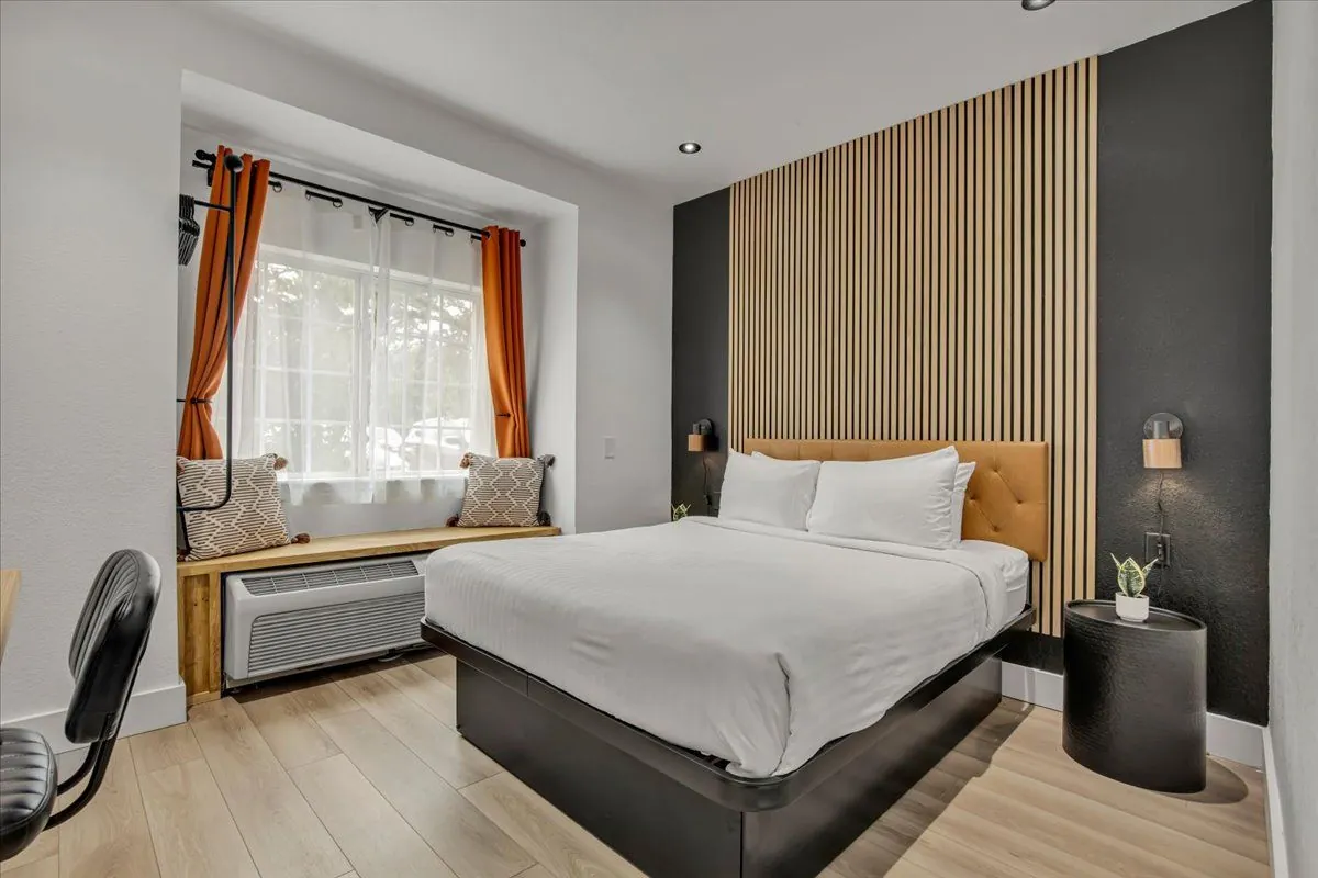 Boutique King – room with window bench seat, curtains, and bed