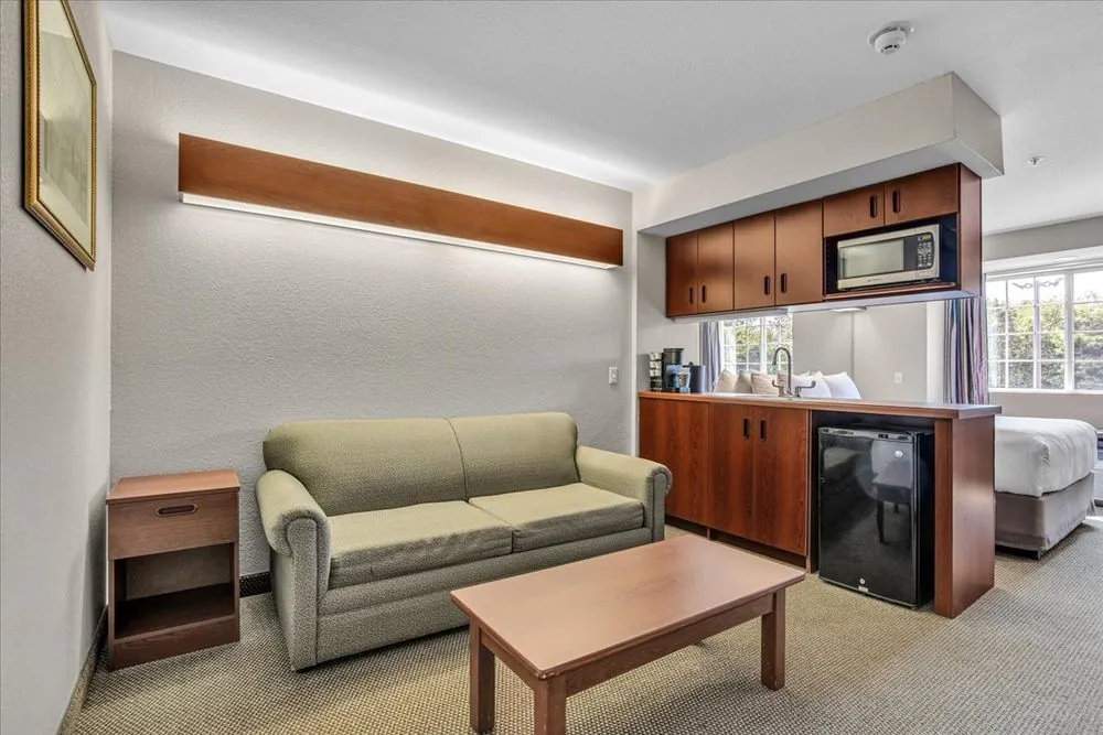 Classic Queen Suite – seating area with sofa, mini fridge, and coffee table