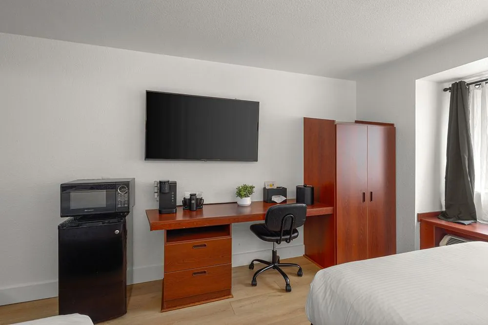 Classic Double Queen – work desk with chair, TV, and wood wardrobe