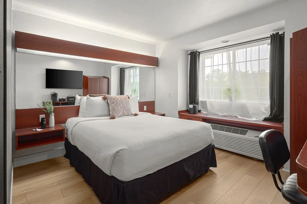 Classic Queen – double queen beds with wood slat accent wall and curtained window