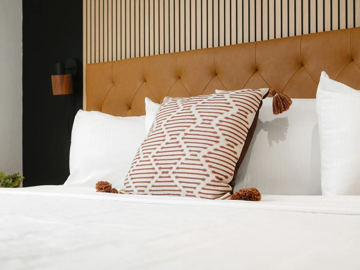 Boutique King Suite – close-up of leather headboard with white and patterned pillows
