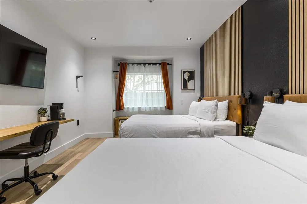Boutique Double Queen – double queen beds with desk and curtained window