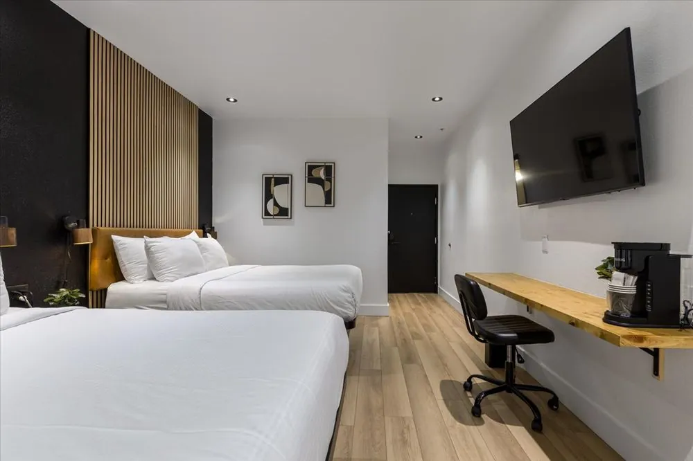 Boutique Double Queen – double queen beds with wood slat accent wall and wall-mounted TV